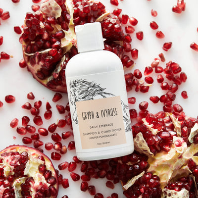 Daily Embrace Shampoo + Conditioner on a bed of pomegranate