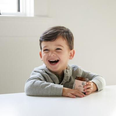 Child laughing while eating a chocolate probiotic heart